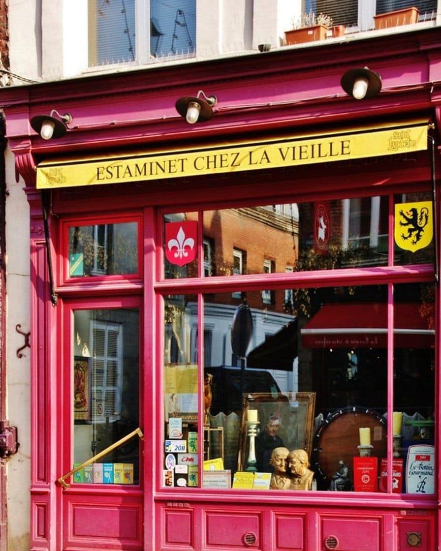 Front of a Lille estaminet with its metal shutter down during the braderie, the pavement taken over by flea market stalls and passers-by in front