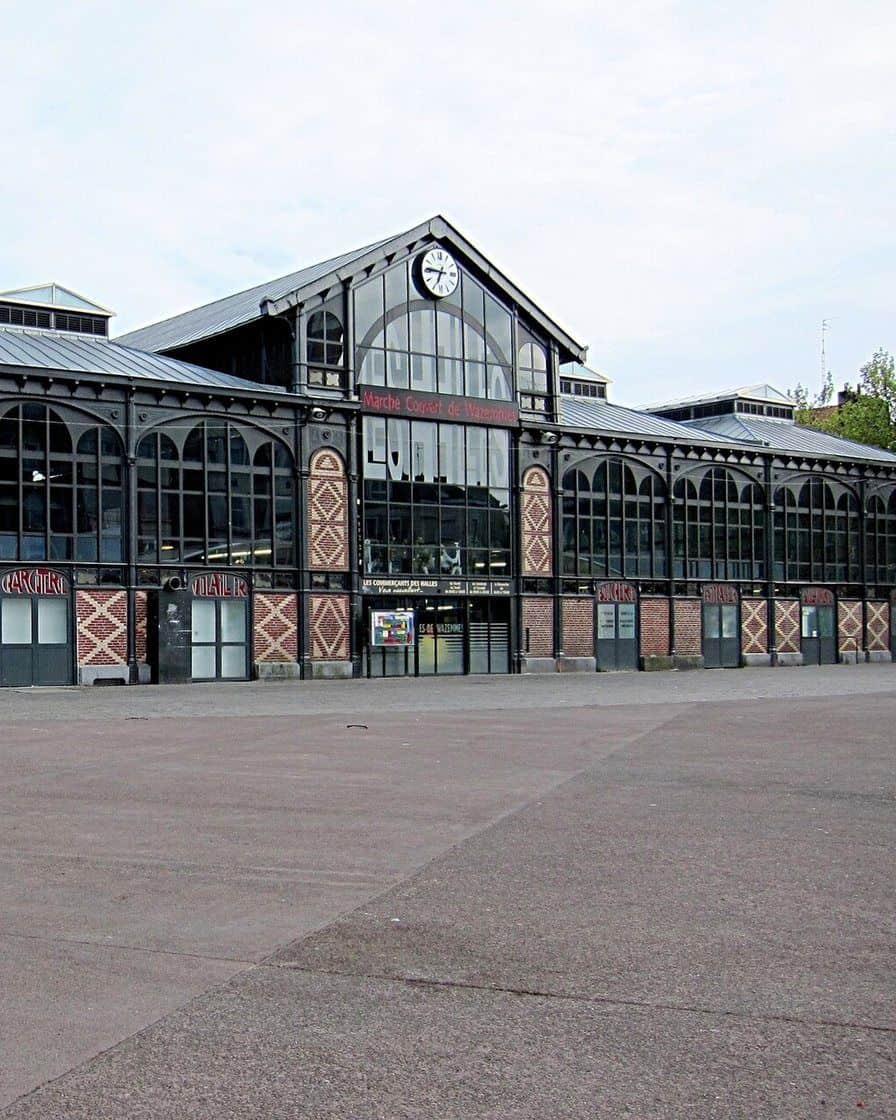 Wazemmes covered market in Lille, a 19th-century iron hall with colourful fruit and vegetable stalls in front of the entrance